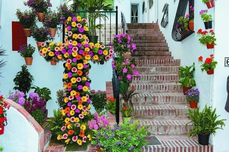 a cross made of flowers is in front of a set of stairs