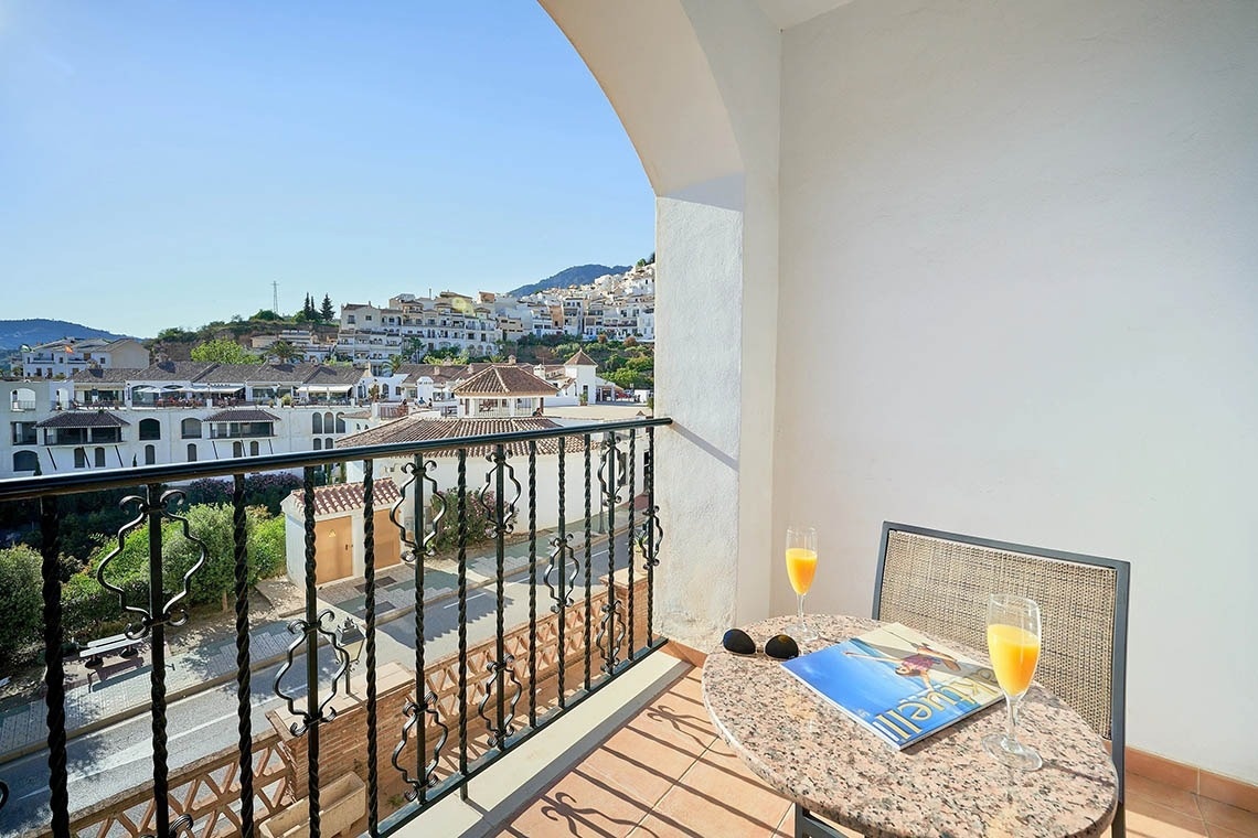 un balcón con una mesa y una silla y una revista sobre la mesa