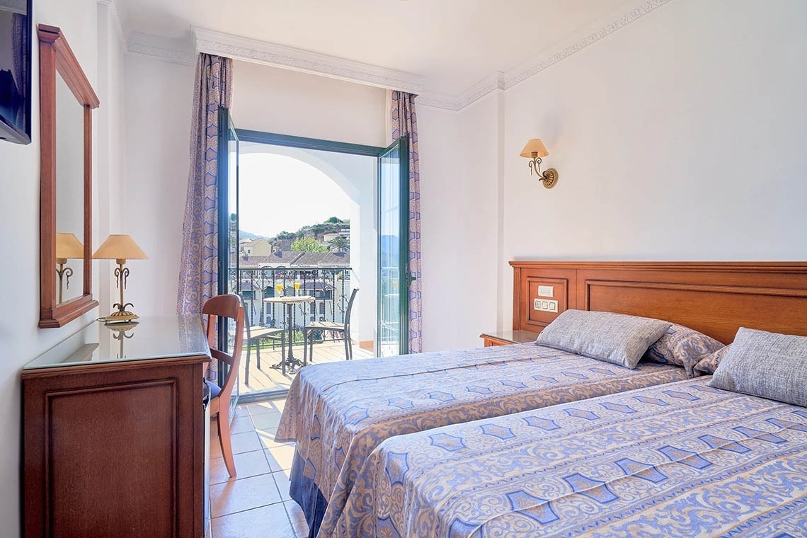 una habitación de hotel con dos camas y una mesa