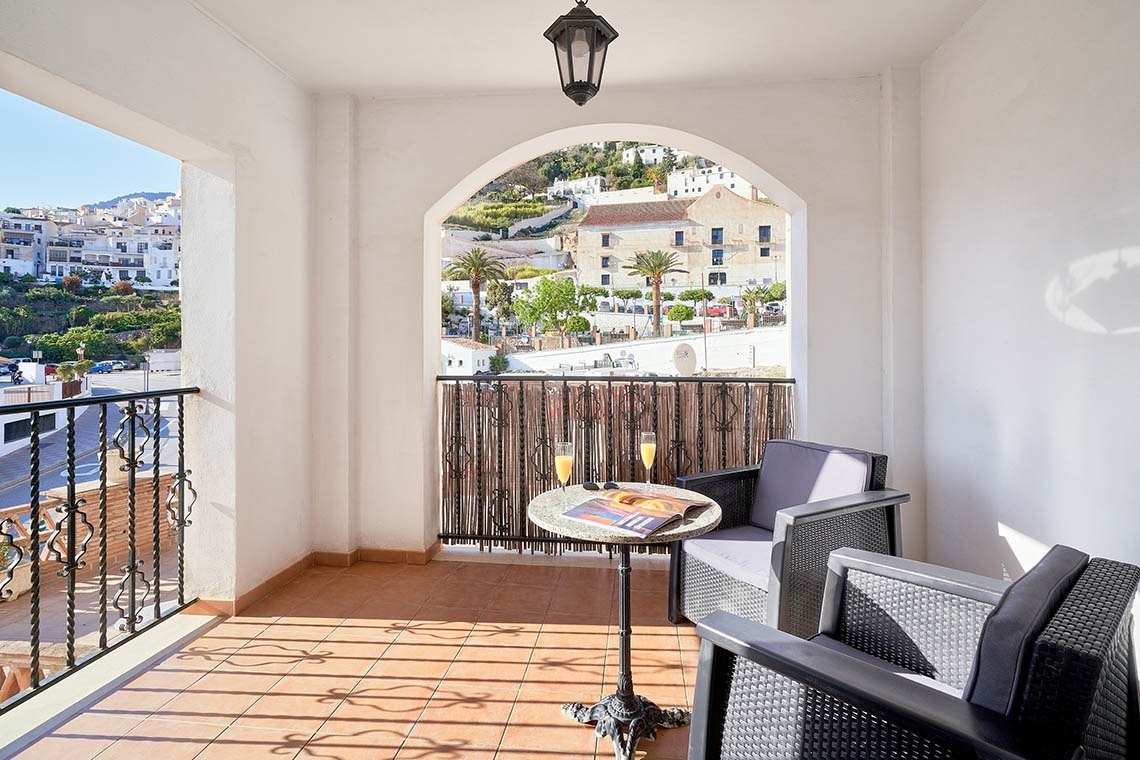 un balcón con una mesa y sillas y una vista de una ciudad