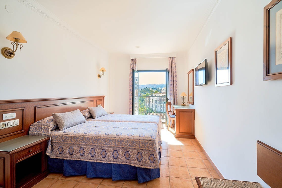 a hotel room with two beds and a balcony