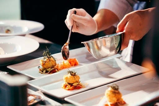 a chef is preparing a plate of food with a spoon .