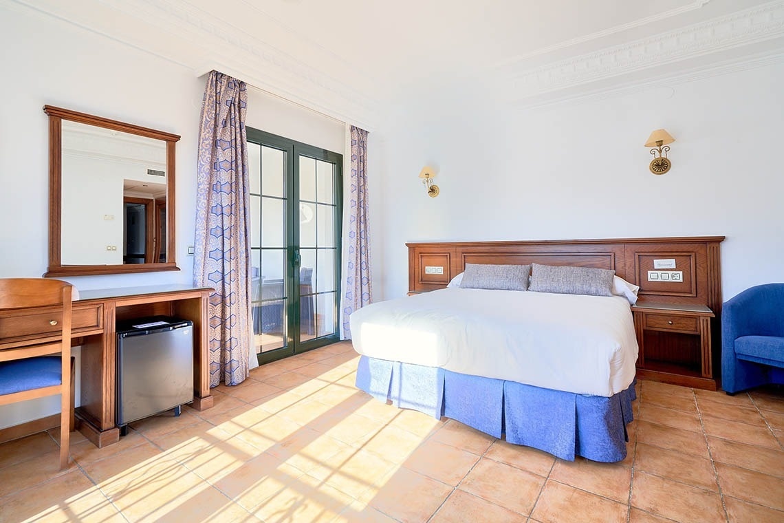 una habitación de hotel con una cama y un escritorio