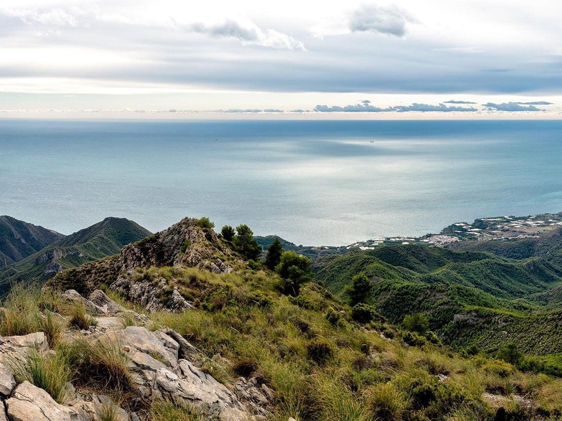 a view of the ocean with mountains in the foreground