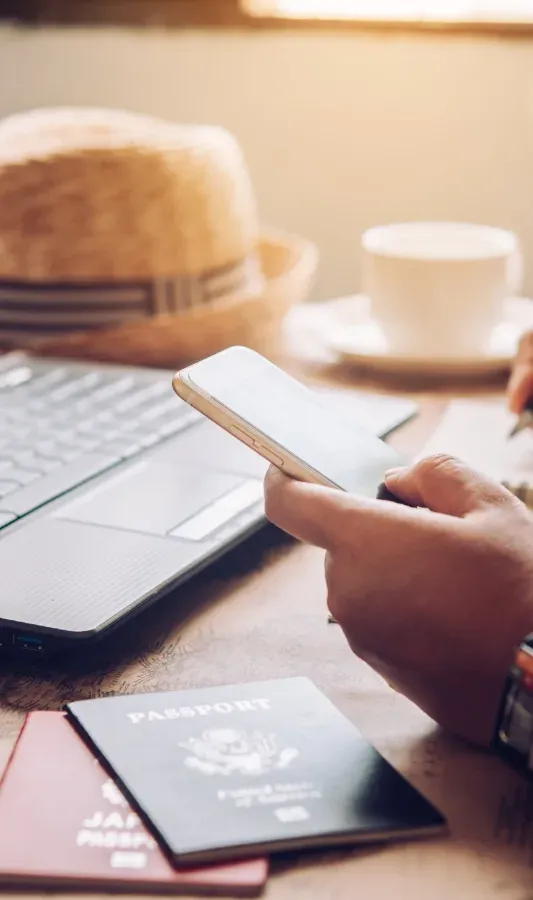 Planifica tu viaje corporativo NEXTA: Pasaportes, laptop y café.