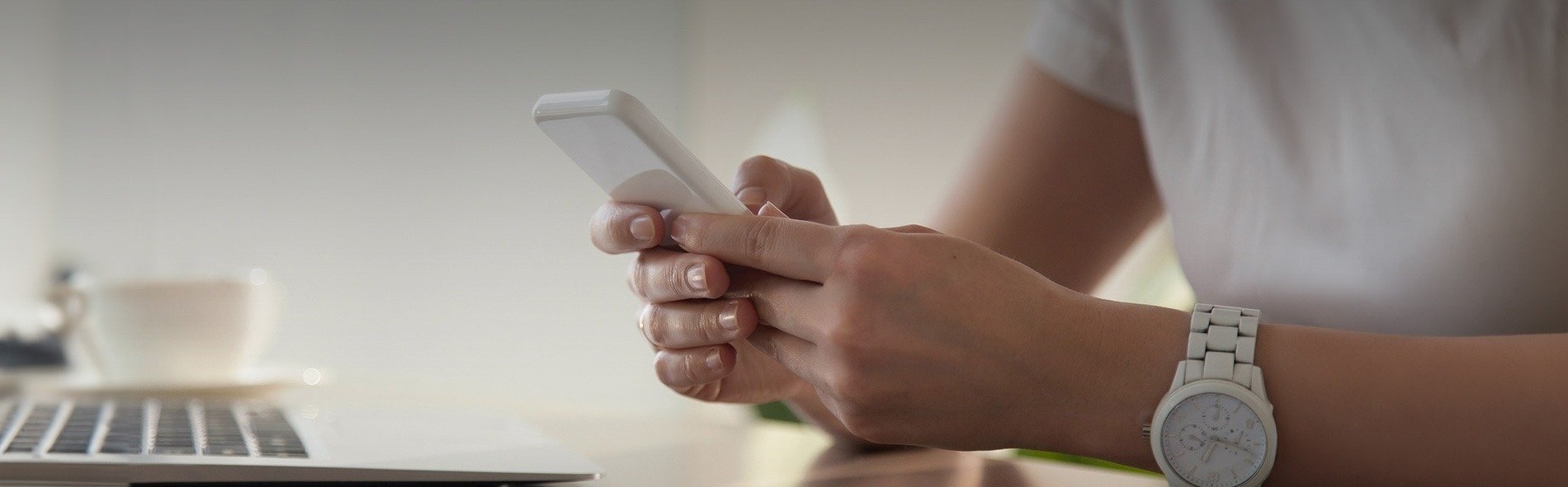 a woman wearing a watch is using a cell phone