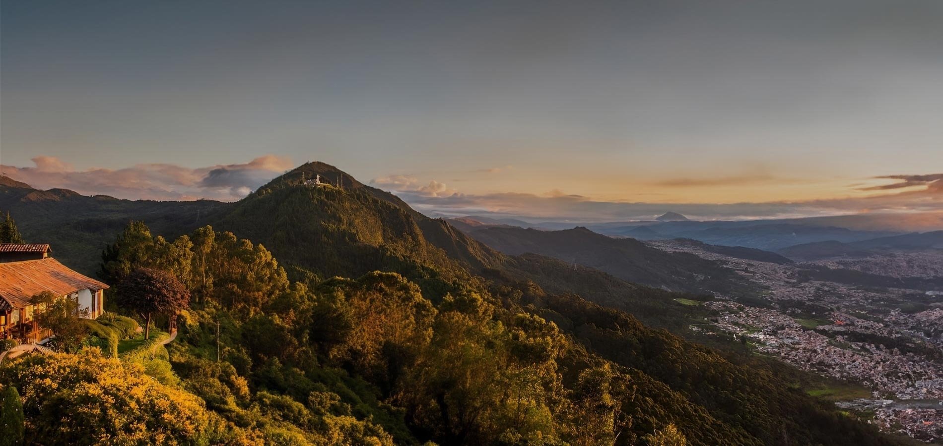 una vista aérea de una ciudad y montañas al atardecer