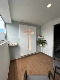 una habitación con una cruz blanca en la pared