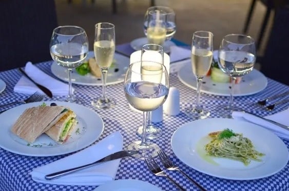 una mesa con platos de comida y copas de vino .