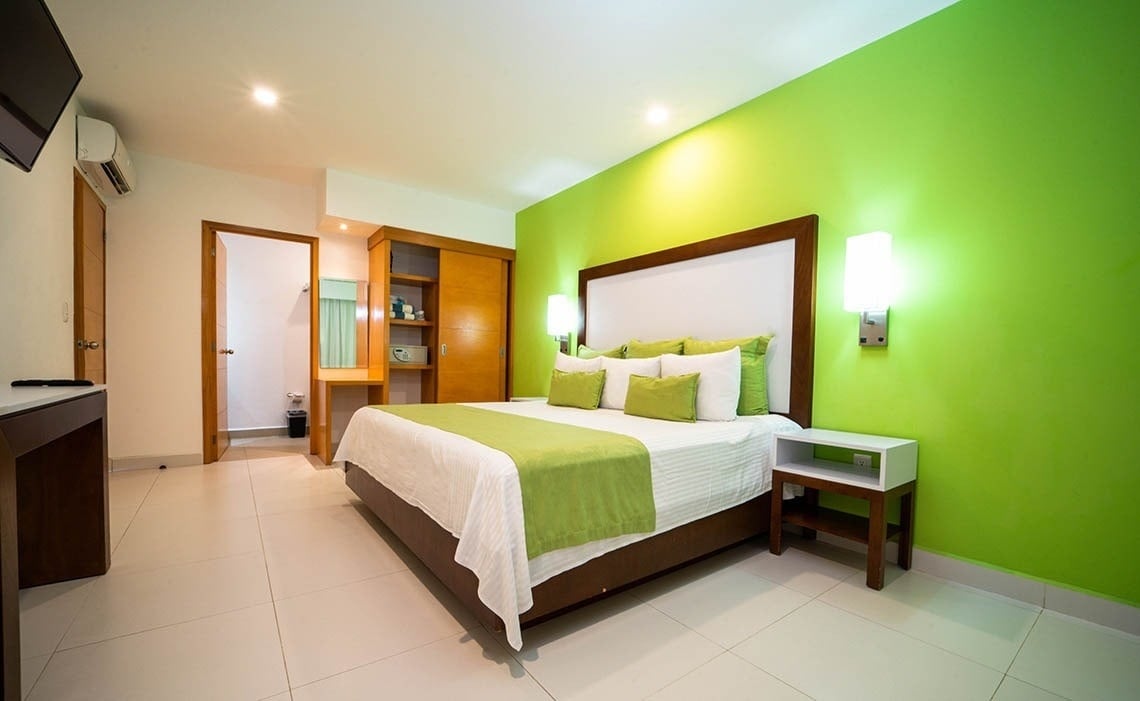 a hotel room with green walls and a bed