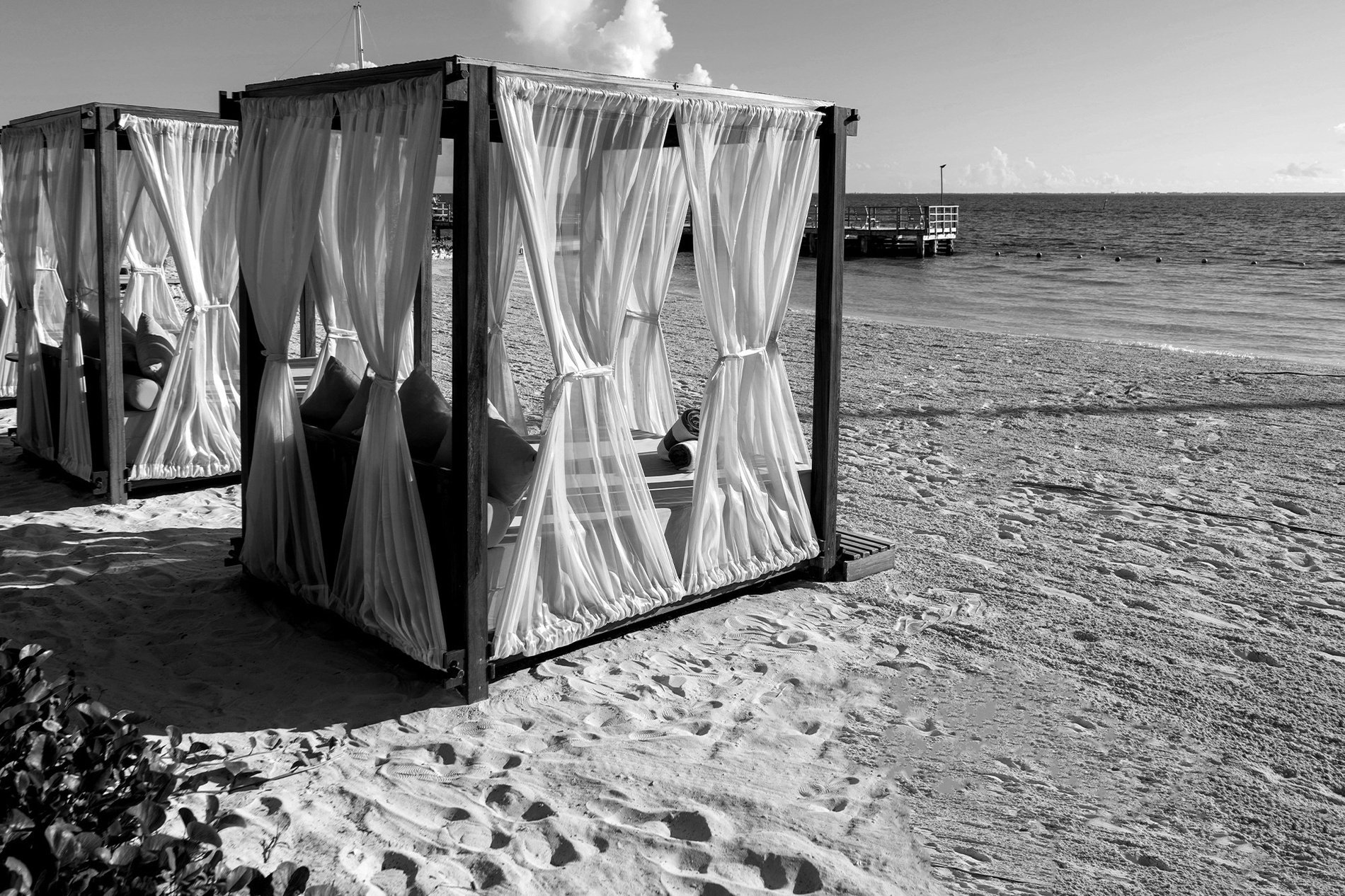 a black and white photo of canopies on a beach=s1900