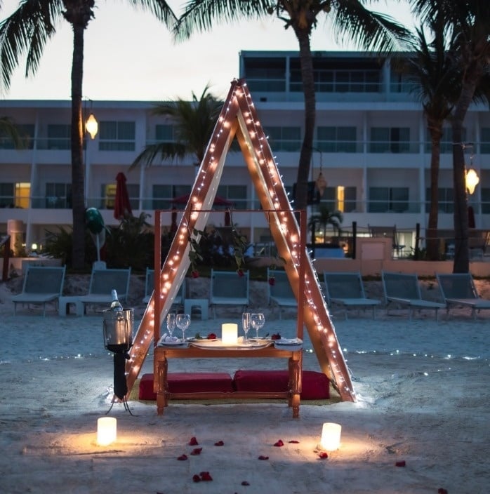 una mesa en la playa está decorada con luces y velas