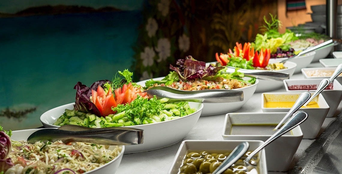 una mesa llena de platos de ensaladas y salsas