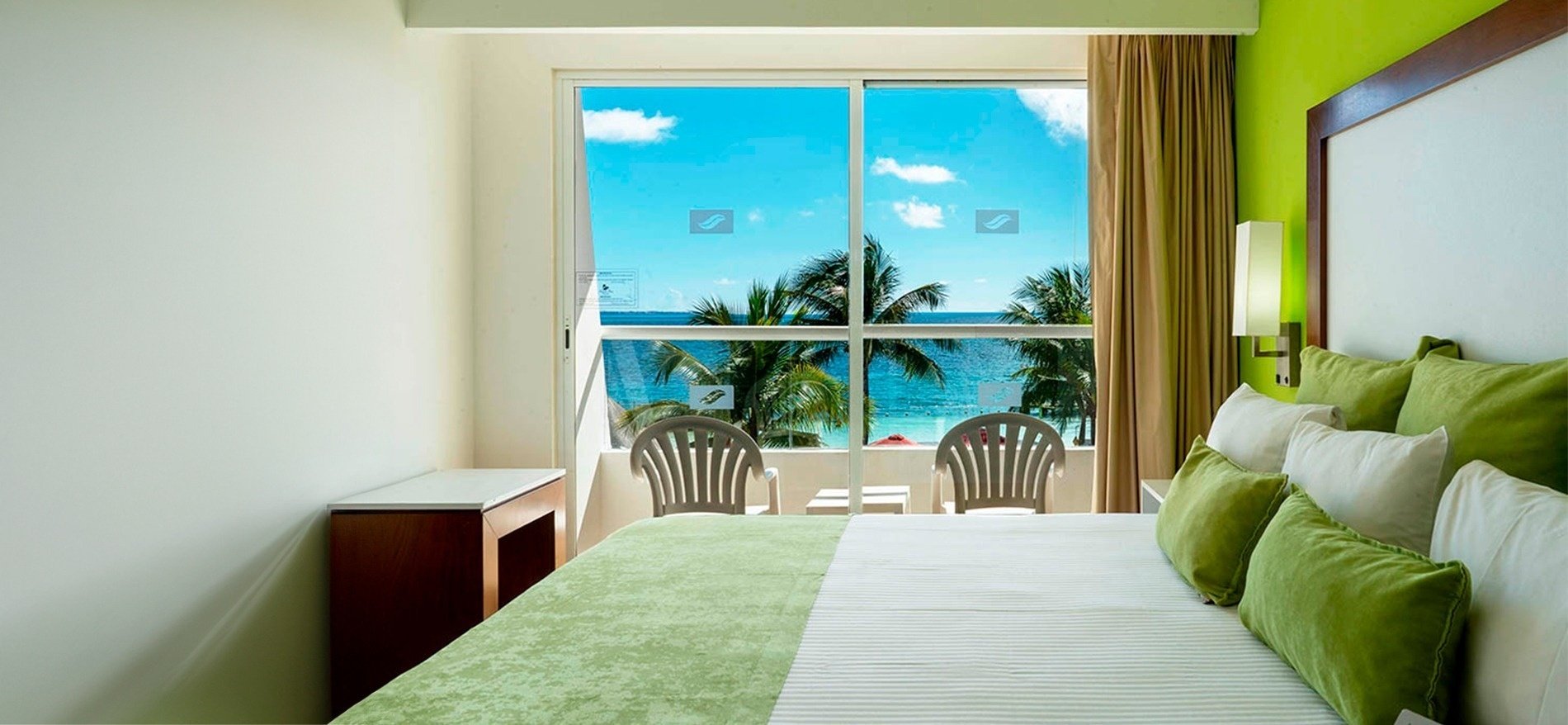 una habitación con cama y sillas con vista al océano