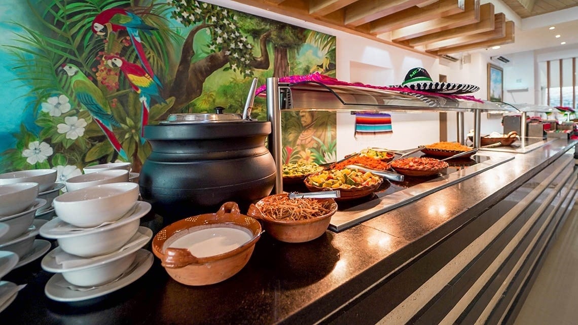 a buffet with a painting of parrots on the wall