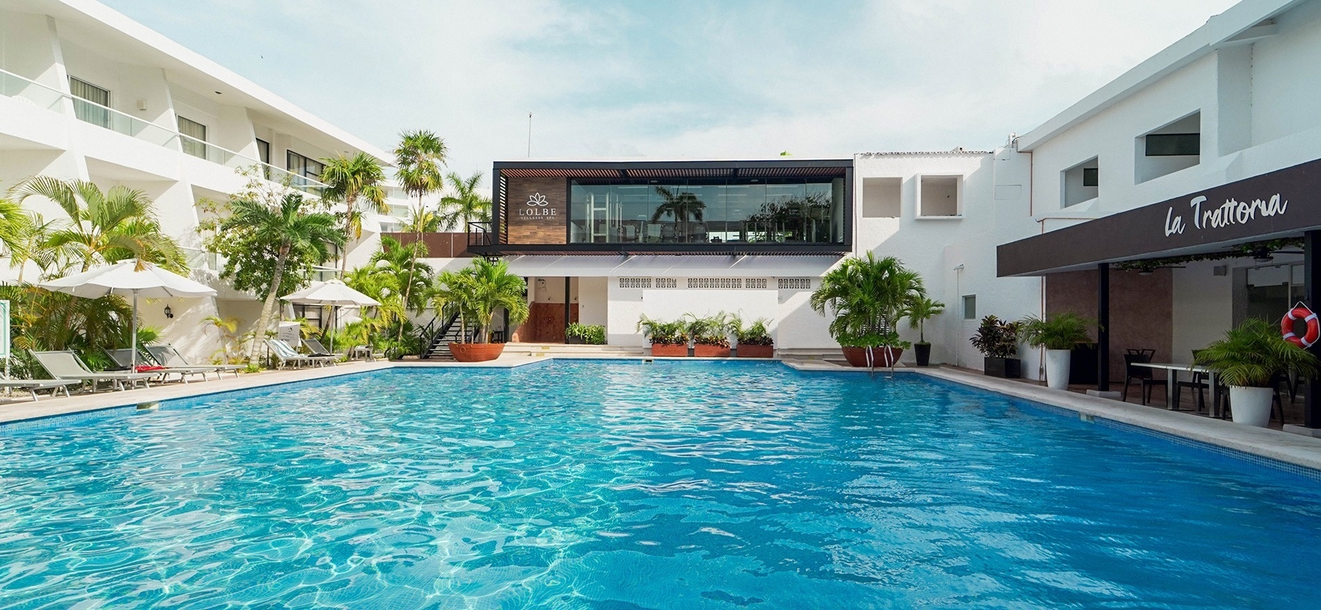 a large swimming pool in front of a building that says la trattoria