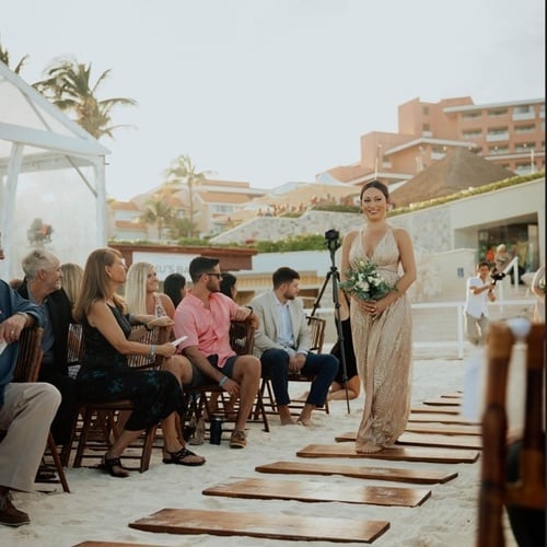 una novia camina por el pasillo de una boda en la playa