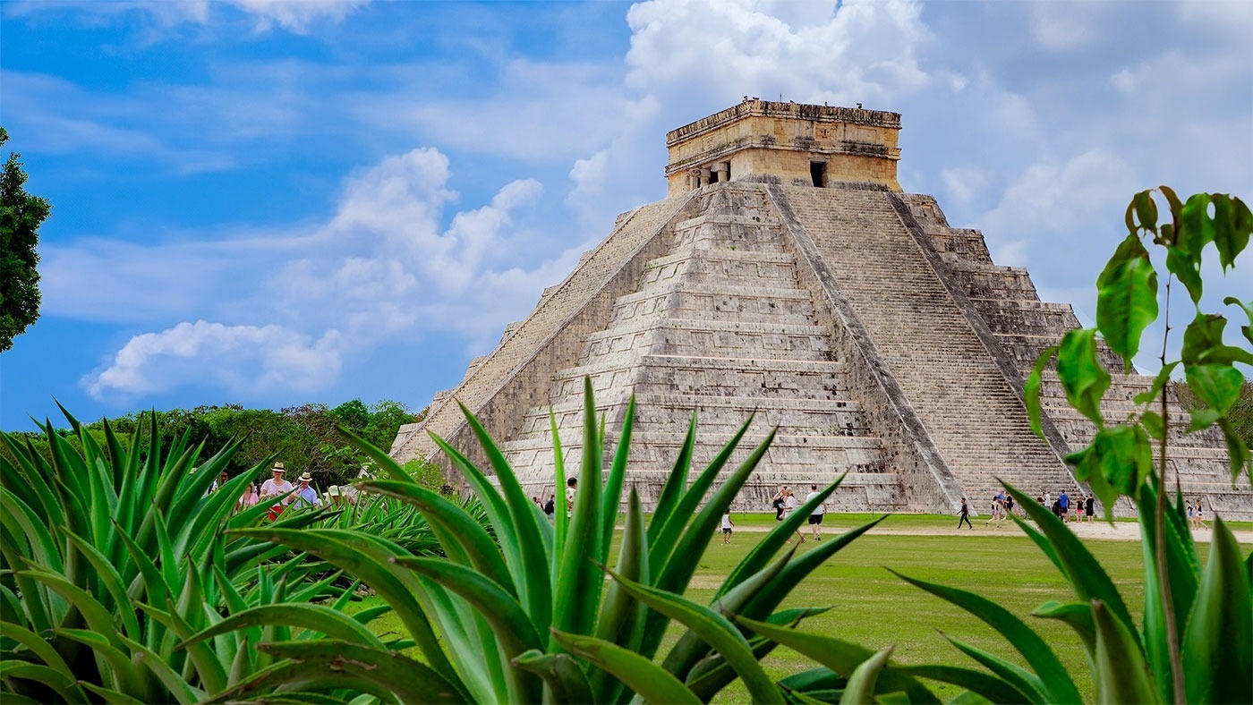 a group of people standing in front of a pyramid