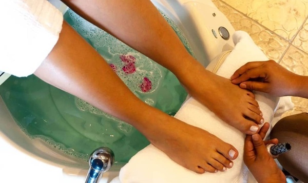 a woman is getting her feet painted in a bathtub