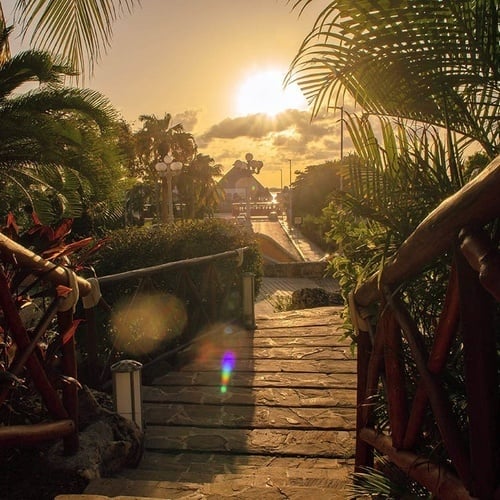 una escalera de madera conduce a un edificio al atardecer