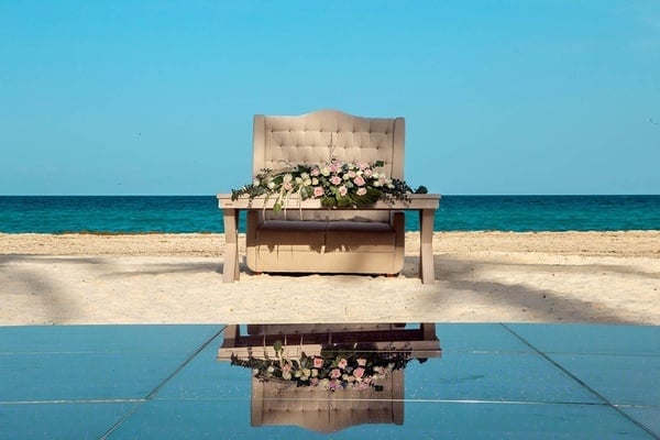 una silla decorada con flores se sienta en la playa