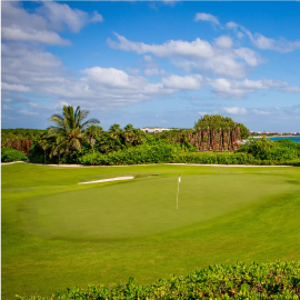 un campo de golf con una bandera blanca en el primer green