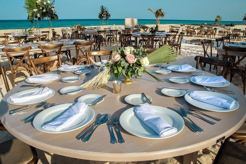 a table set for a wedding reception on the beach