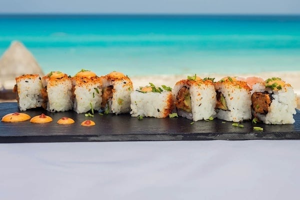 un plato de sushi está sobre una mesa frente a la playa