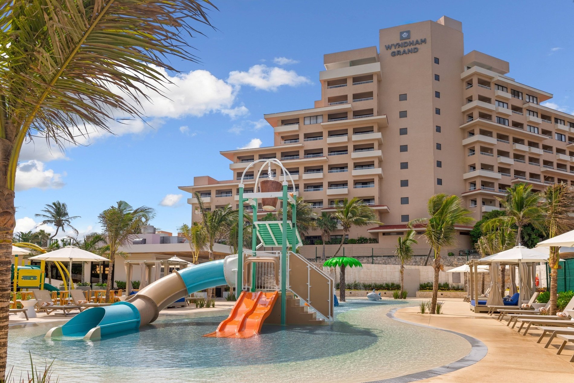 una piscina con toboganes y un hotel en el fondo