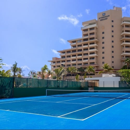 una cancha de tenis frente a un gran hotel