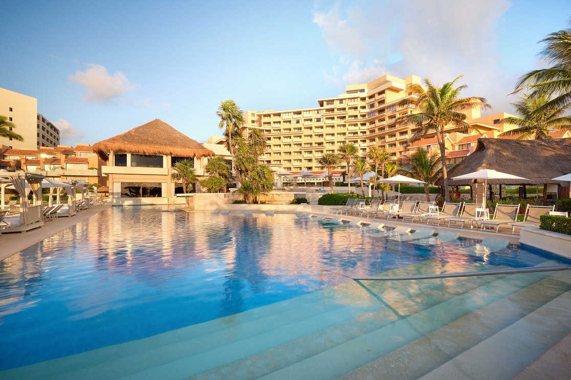 una gran piscina en un resort con un gran edificio en el fondo