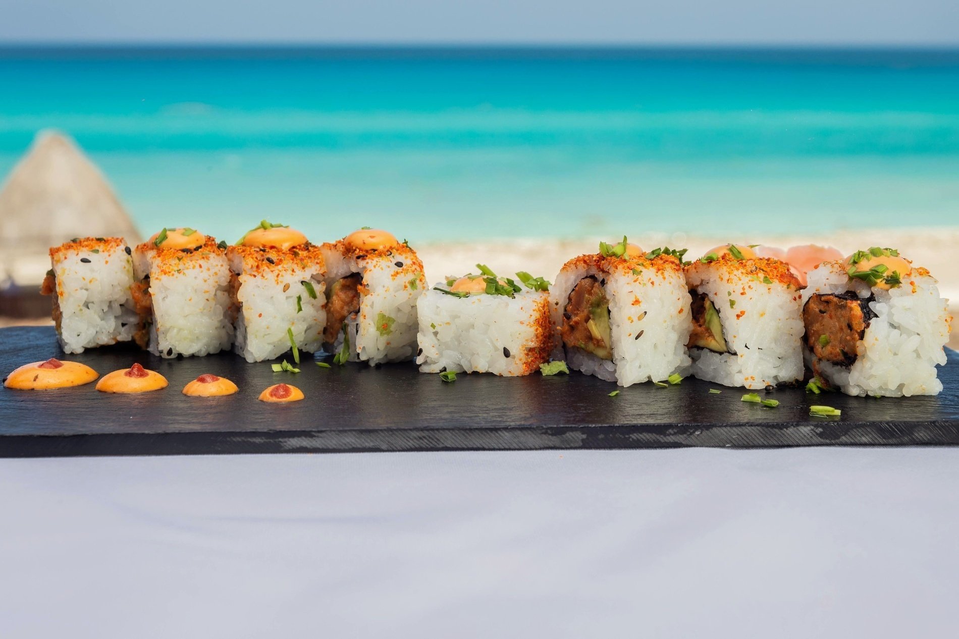 un plato de sushi con una playa en el fondo