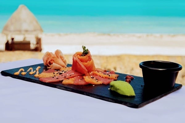 un plato de comida en una mesa con una playa en el fondo