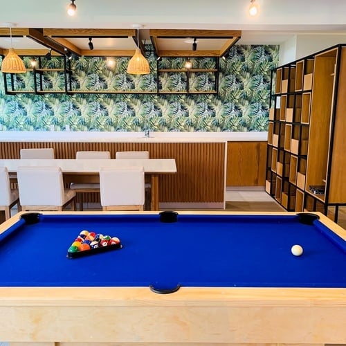 a pool table in a room with a table and chairs