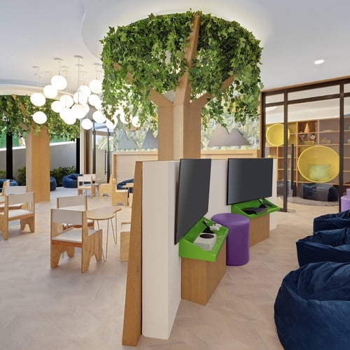 a room with tables and chairs and a tree in the middle