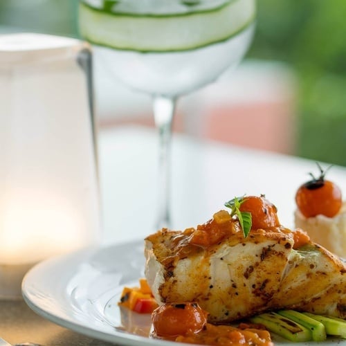 a plate of food with a glass of water in the background