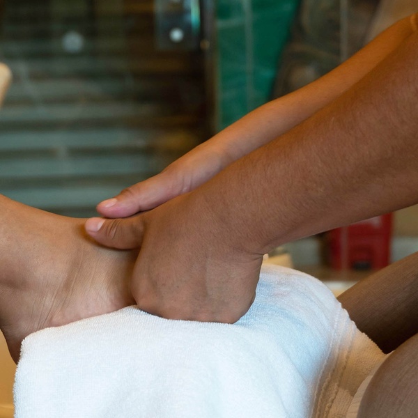 a person 's foot is being massaged on a white towel