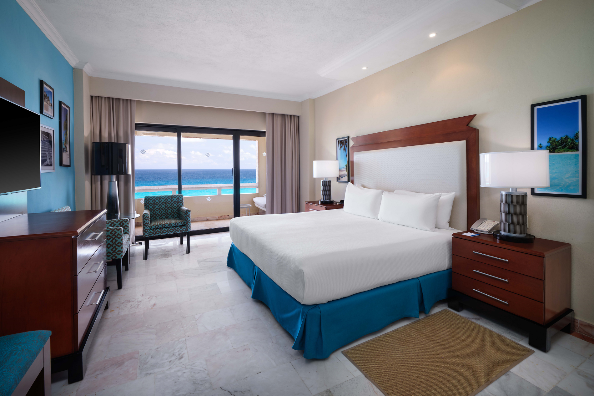 a hotel room with two beds and a balcony overlooking the ocean