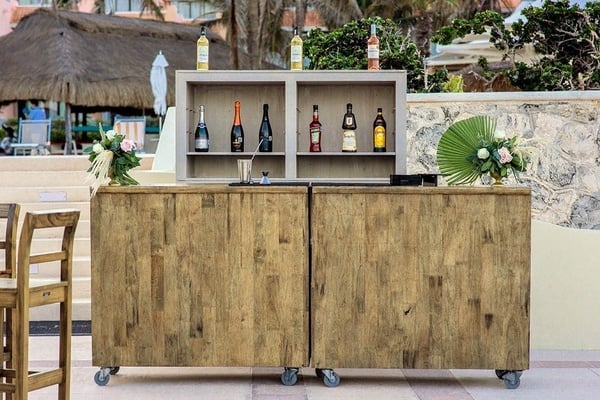 una barra de madera con botellas de alcohol encima