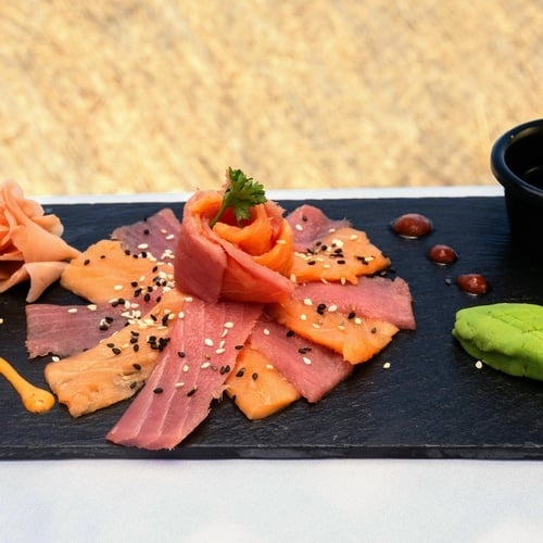 a plate of food with salmon and tuna on it