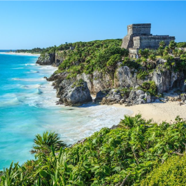 una playa con un castillo en la cima de la colina