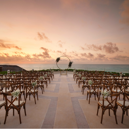 Sunset wedding setup on a rooftop terrace.
