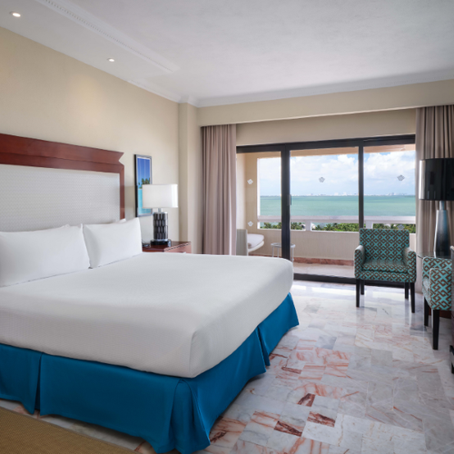 a hotel room with a king size bed and a view of the ocean