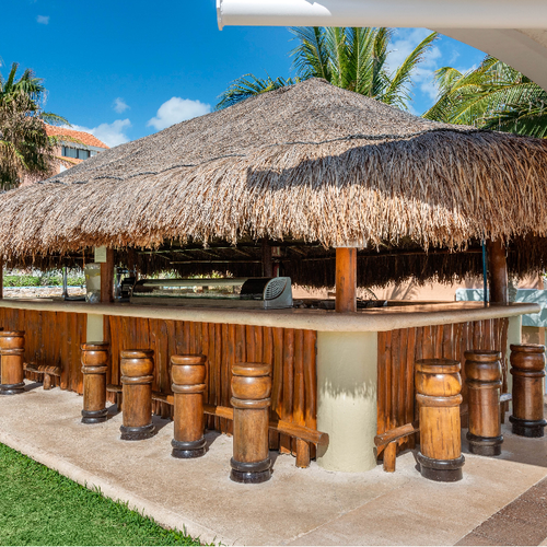 a thatched hut with a bar underneath it