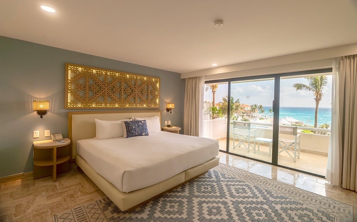 una habitación de hotel con una cama king size y una puerta corrediza al balcón