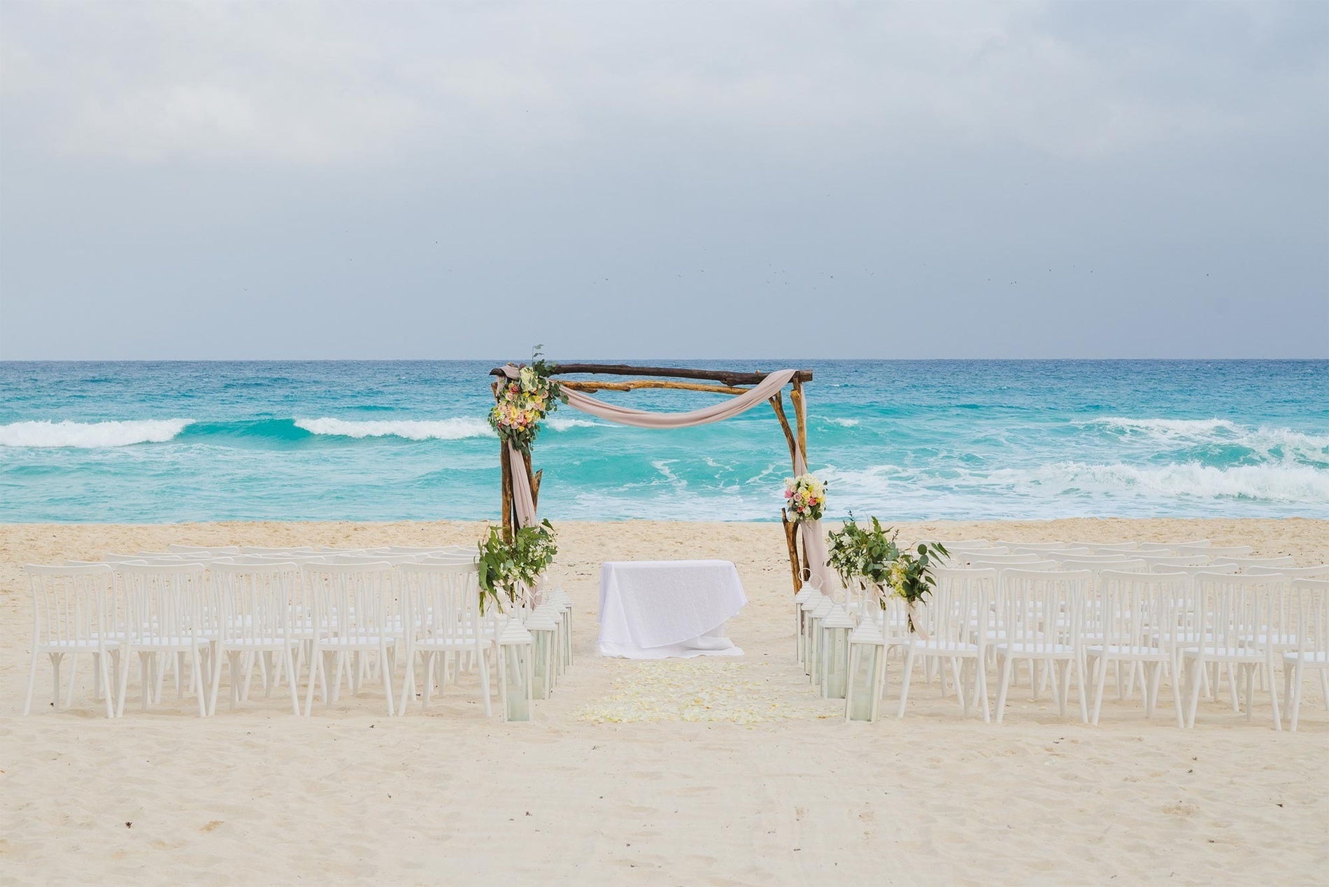 una ceremonia de boda en un balcón con vistas al océano al atardecer .