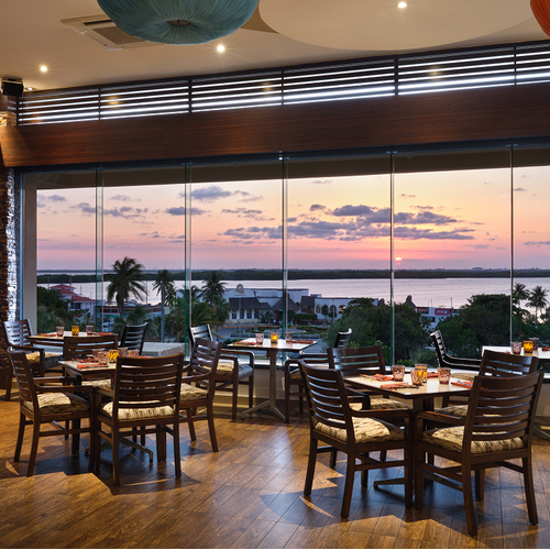 a restaurant with tables and chairs and a view of the ocean