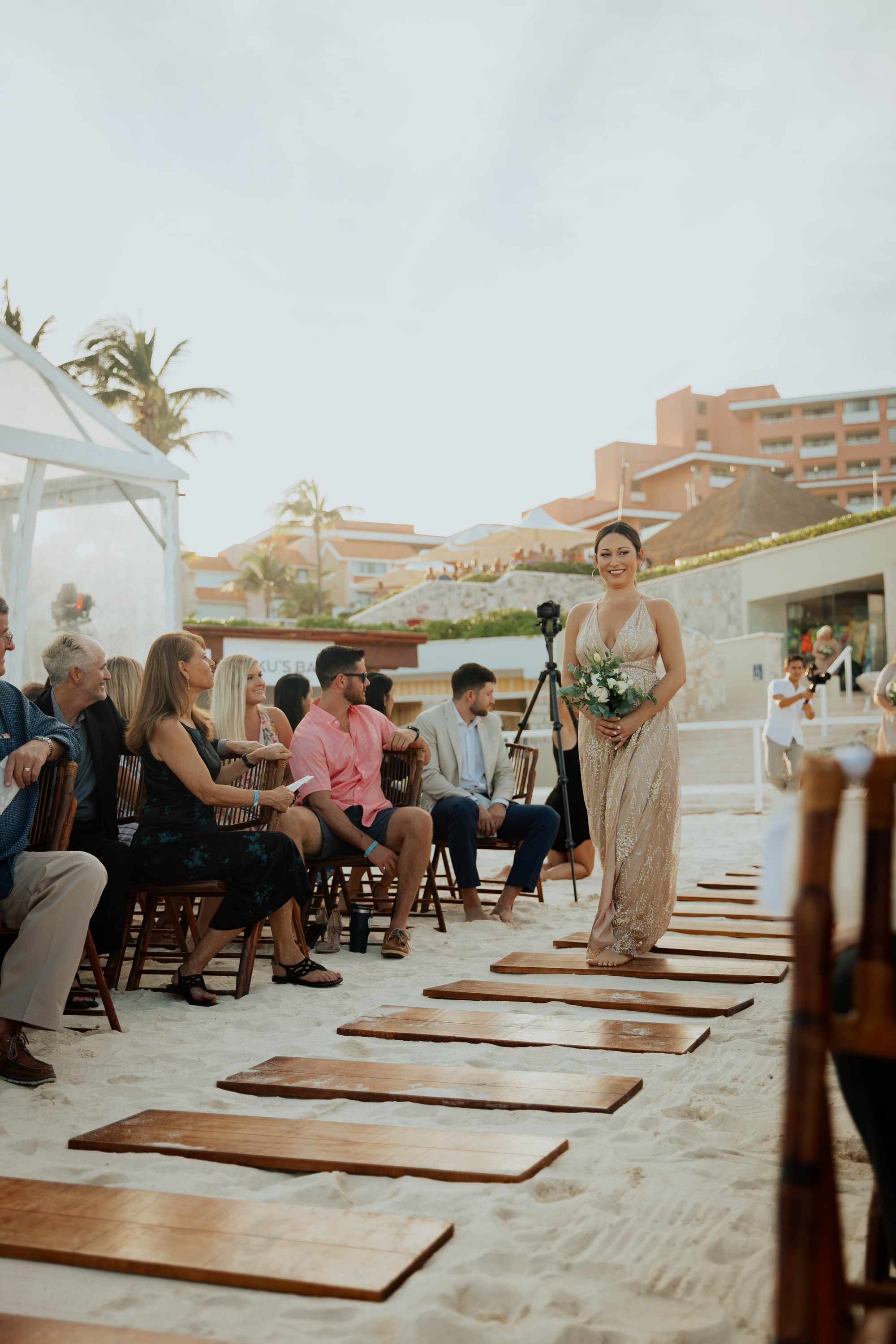 una novia camina por el pasillo de una boda en la playa
