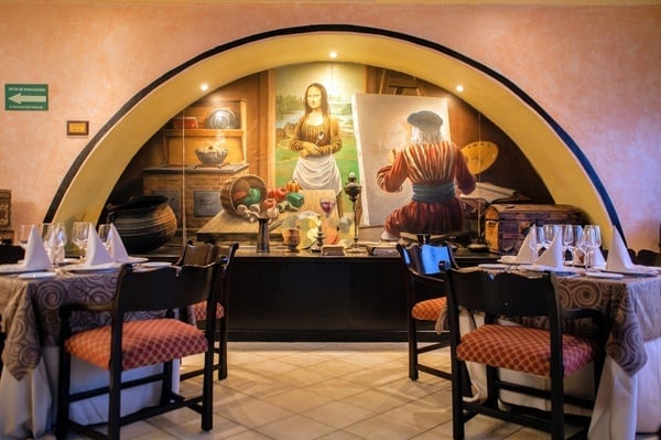 un restaurante con una pintura de la mona lisa en la pared