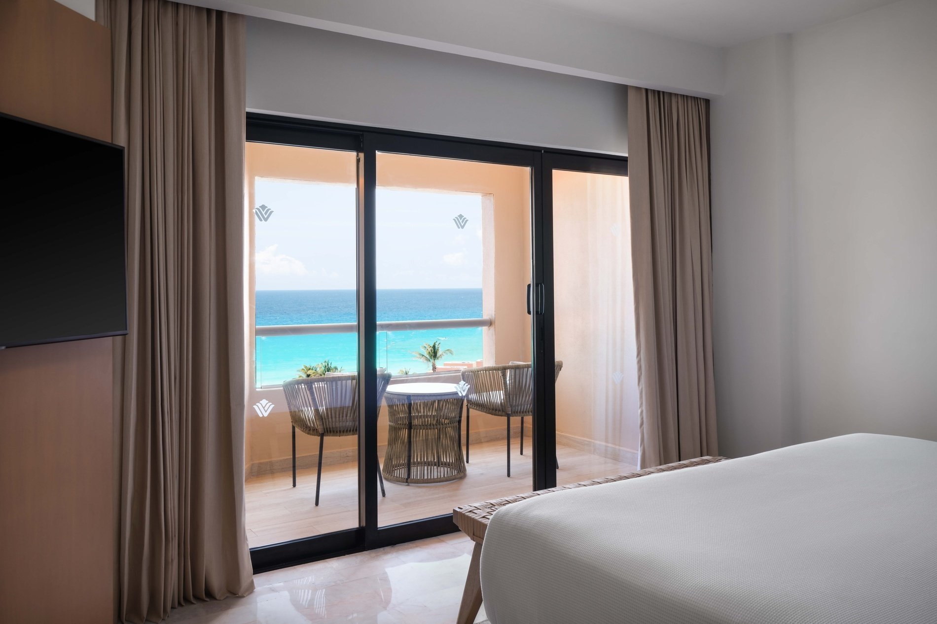 una habitación con una cama y una televisión con vista al océano